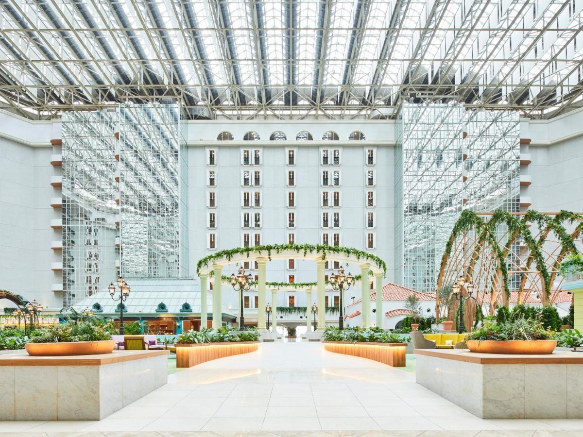 Grand Nikko Tokyo Bay Maihama Urayasu Exterior foto The photo shows a spacious atrium or indoor area of a building, likely a hotel or resort. The architecture features large glass panels overhead, allowing for natural light to flood the space. There are elegant decorative elements, such as arches ador