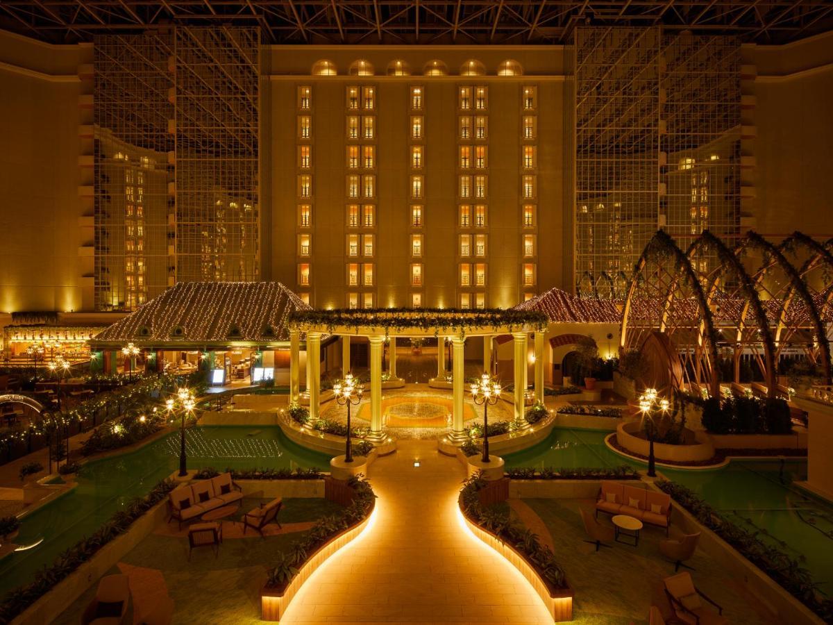 Grand Nikko Tokyo Bay Maihama Urayasu Exterior foto The photo shows a beautifully illuminated indoor space resembling a luxury hotel or resort. There are elegant architectural features, including large columns, arches, and decorative lighting. The area is designed with lush greenery and well-maintaine