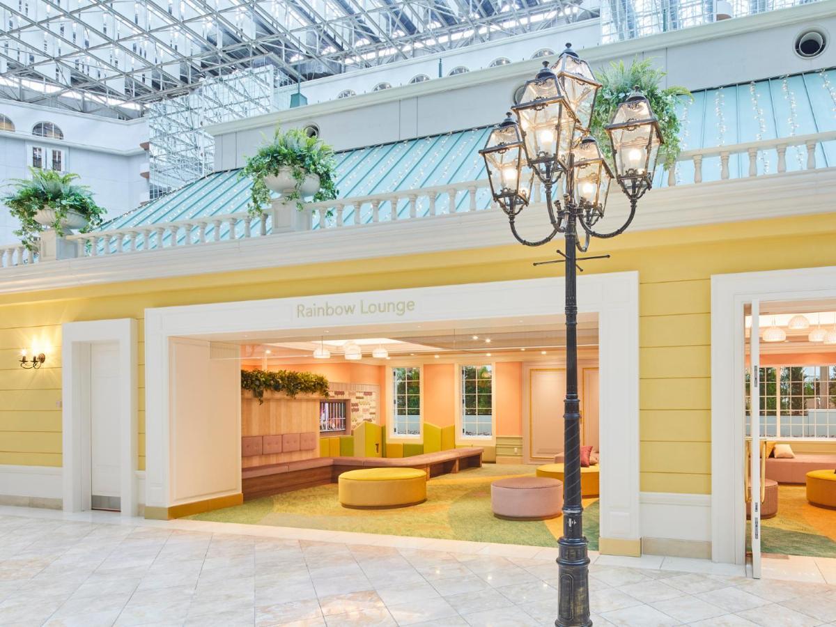 Grand Nikko Tokyo Bay Maihama Urayasu Exterior foto The photo shows an indoor lounge area that features bright, pastel colors. The walls are painted yellow, and the entrance is framed with a clean, modern design. Inside the lounge, there are soft, rounded seating options in shades of pink and yellow, 