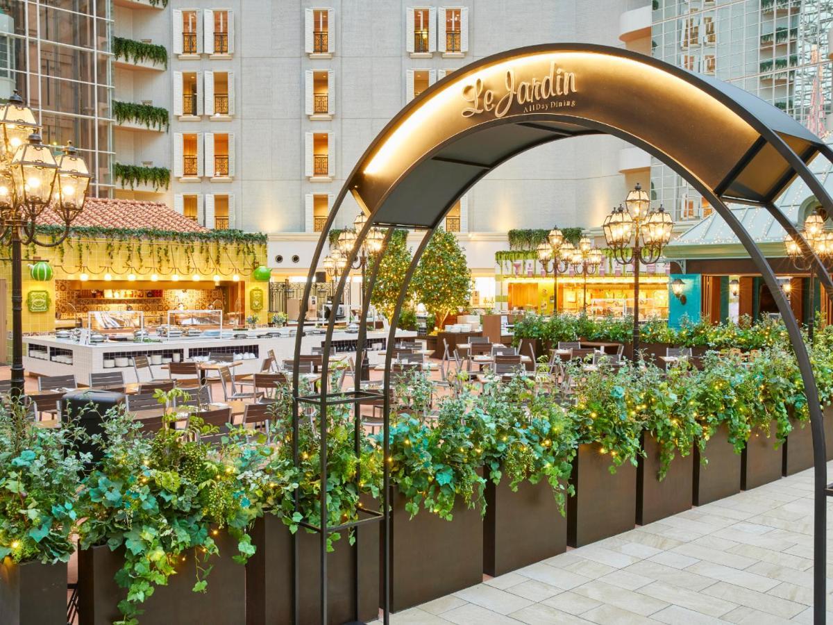 Grand Nikko Tokyo Bay Maihama Urayasu Exterior foto The photo shows an outdoor dining area of a restaurant named "Le Jardin." It features an archway adorned with greenery and decorative lighting. The space is filled with tables and chairs arranged neatly, surrounded by plants that create a lush enviro