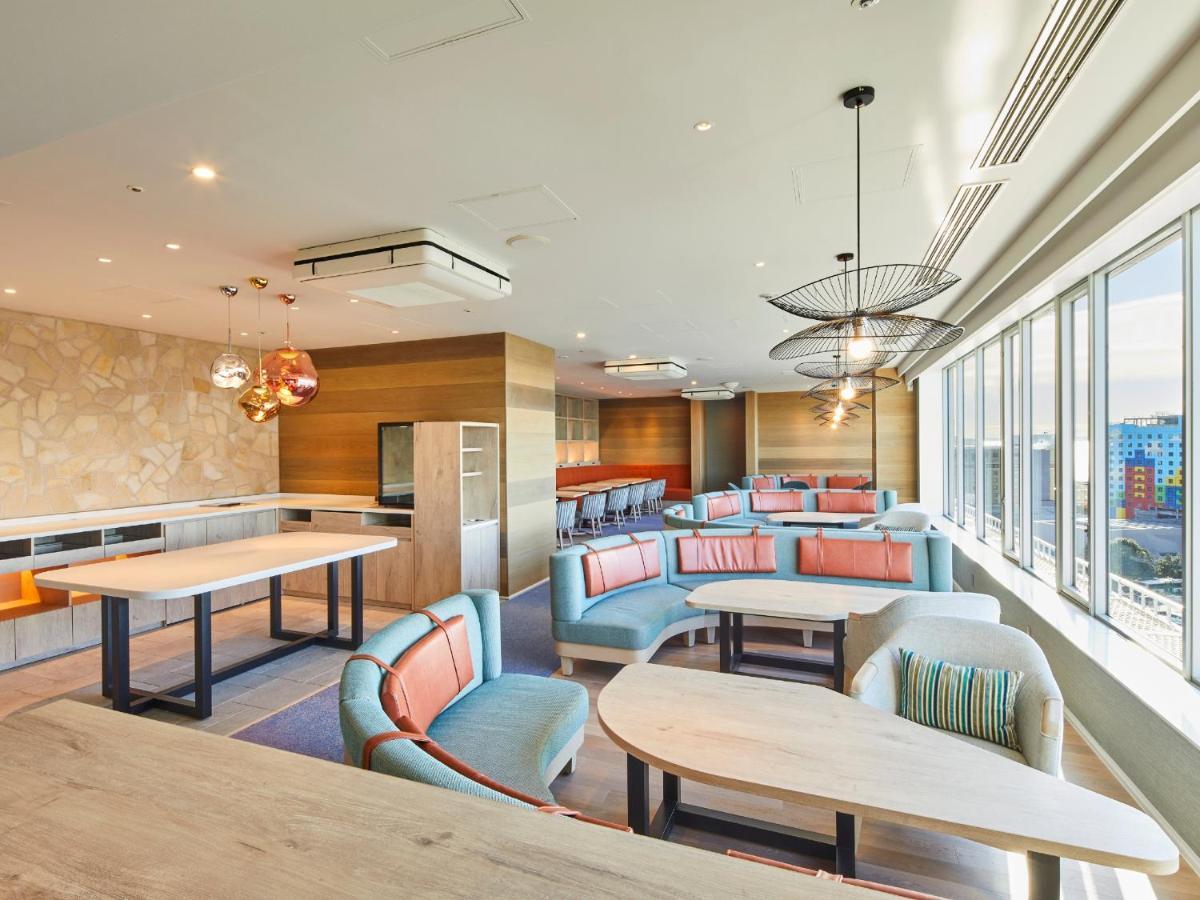 Grand Nikko Tokyo Bay Maihama Urayasu Exterior foto The photo shows a modern and stylish lounge or café area with large windows allowing natural light to fill the space. The interior features comfortable seating arrangements with sofas and tables, predominantly in soft colors, including shades of blue