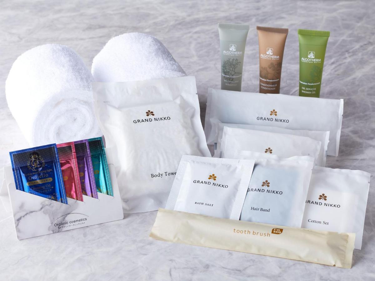 Grand Nikko Tokyo Bay Maihama Urayasu Exterior foto The photo displays a collection of spa or hotel toiletries. It includes:

- Two fluffy white towels.
- Multiple packages labeled "GRAND NAKO," which appear to be spa or body care products.
- Several small tubes of hair and body care items in green an