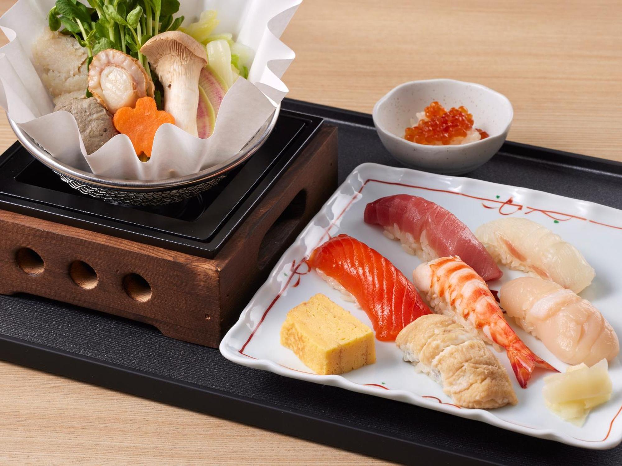 Grand Nikko Tokyo Bay Maihama Urayasu Exterior foto The photo features a Japanese meal presented on a wooden tray. On the left, there is a small pot with a clear broth containing vegetables, mushrooms, and possibly meat, indicated by green herbs and a piece shaped like a flower. On the right, there is